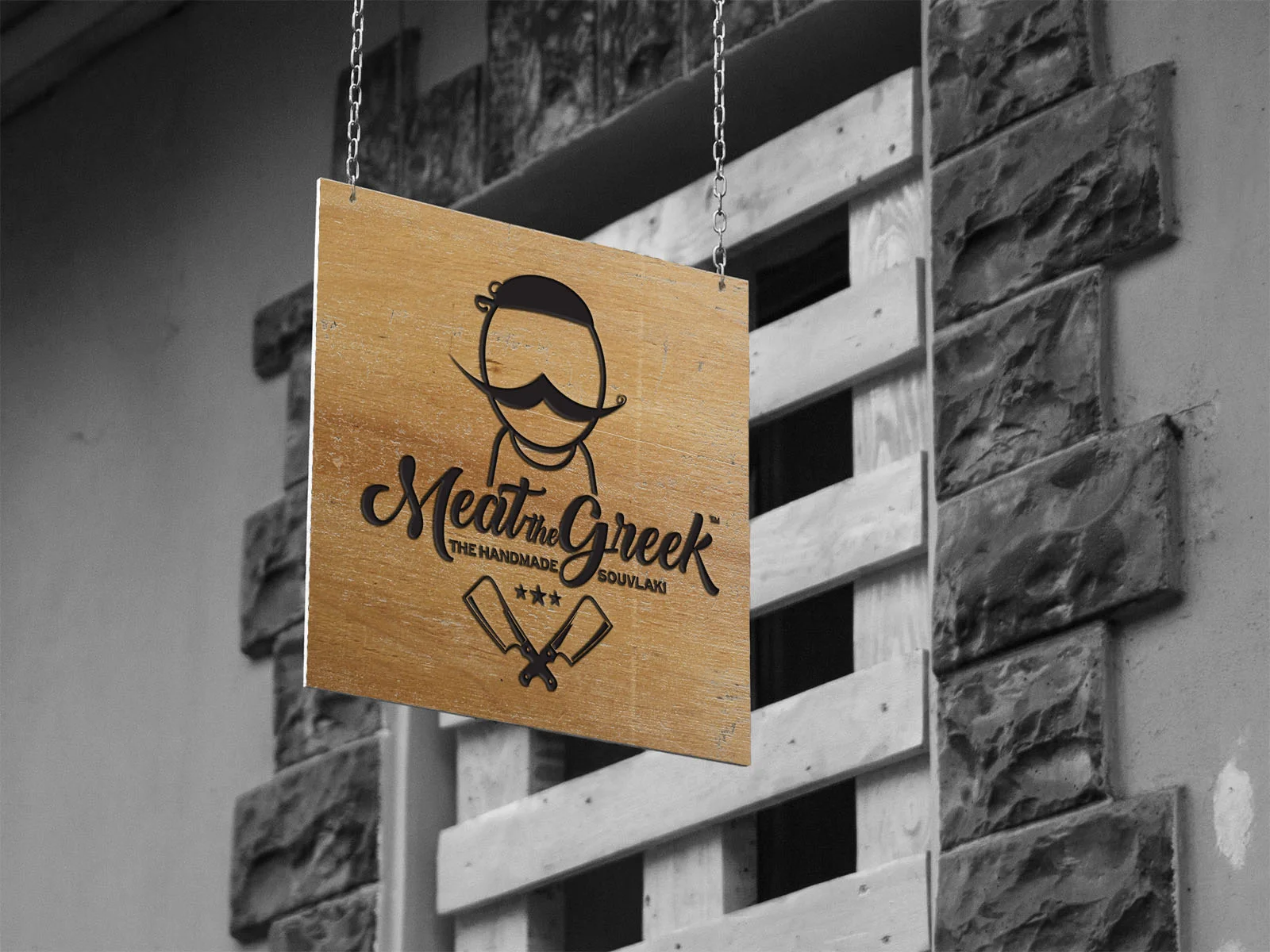 Meat the Greek — wooden hanging sign with the restaurant emblem
