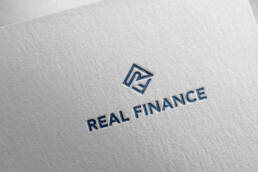 Real Finance logo embossed on white paper
