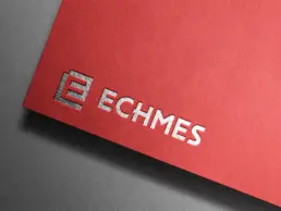 Ανάγλυφο λογότυπο ECHMES με ασημί foil σε κόκκινο χαρτί με υφή