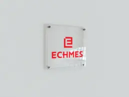 Clear acrylic office sign with the red ECHMES logo
