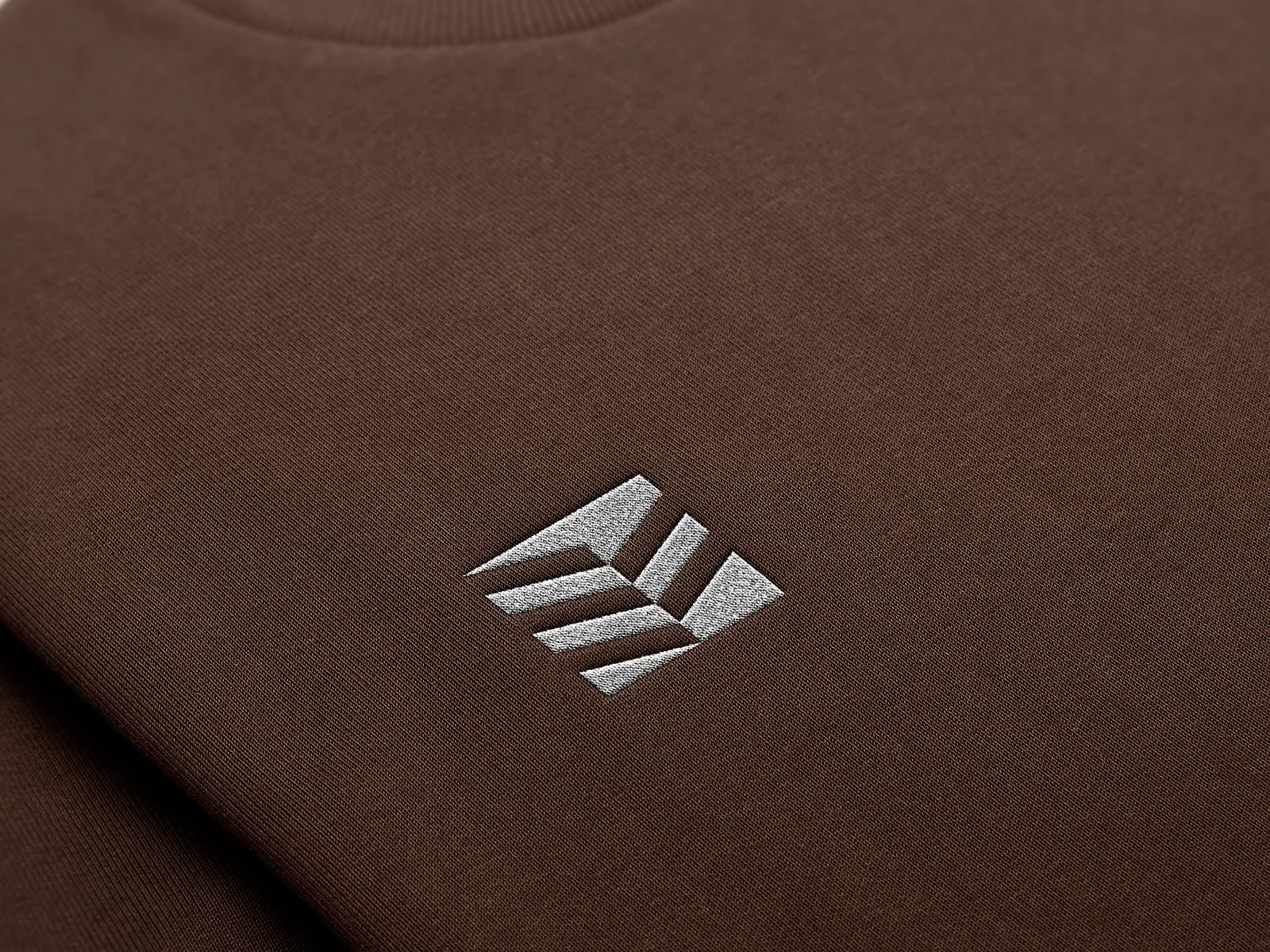 ERMASS geometric logo embroidered on a brown sweater