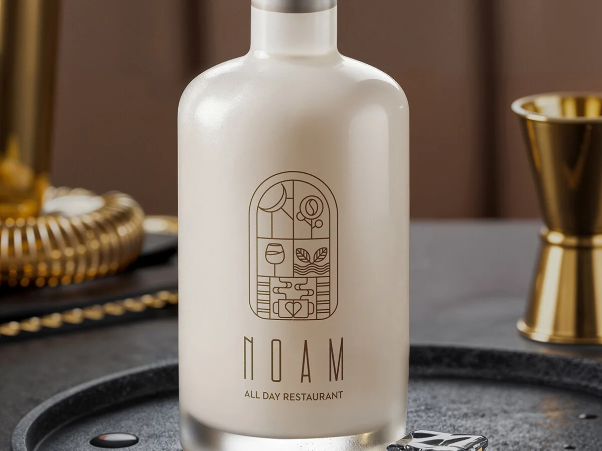 White NOAM bottle with a wooden stopper and gold logo