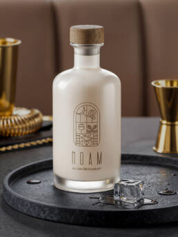 White NOAM bottle with a wooden stopper and gold logo