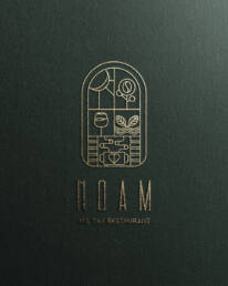 NOAM restaurant logo in gold on textured paper