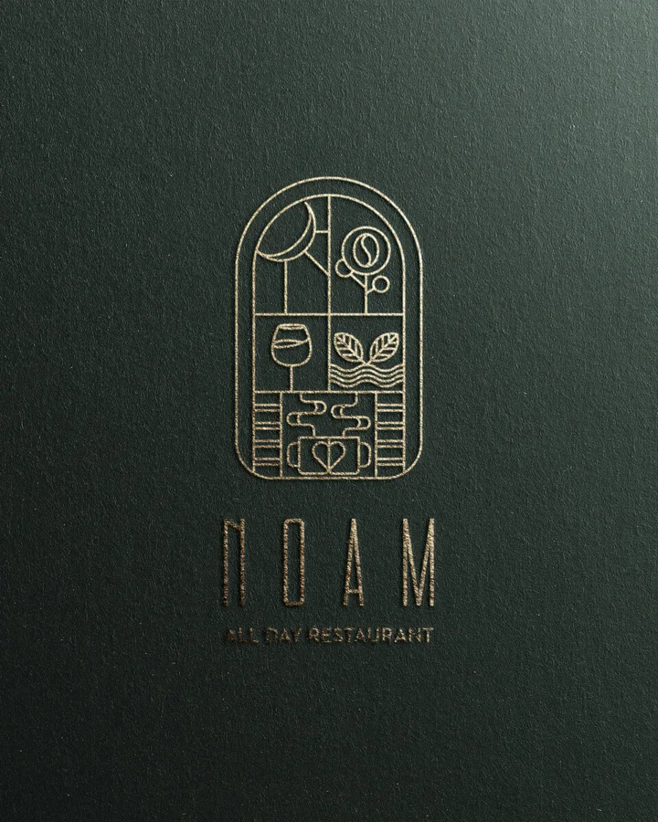 NOAM restaurant logo in gold on textured paper