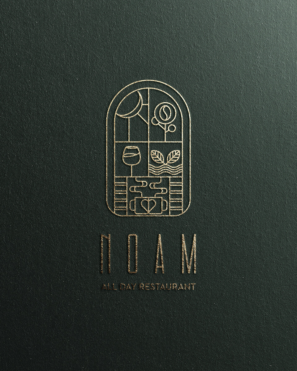 NOAM restaurant logo in gold on textured paper