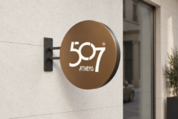 Concept mockup of the 507 Athens logo on a circular bronze exterior hotel sign