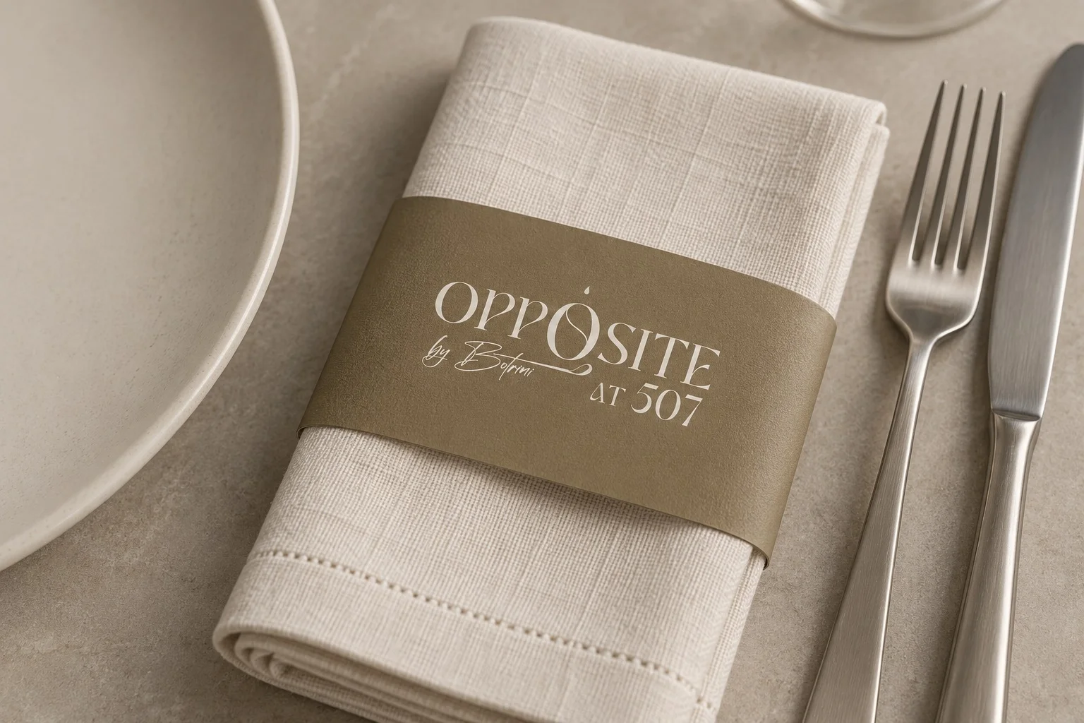 Linen napkin mockup with a gold paper sleeve and the Opposite logo