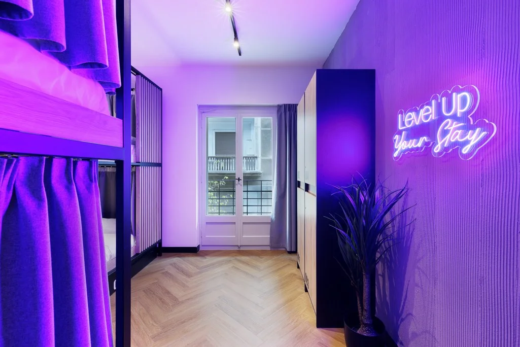 Level Up Your Stay neon sign in a Retroverse dorm room